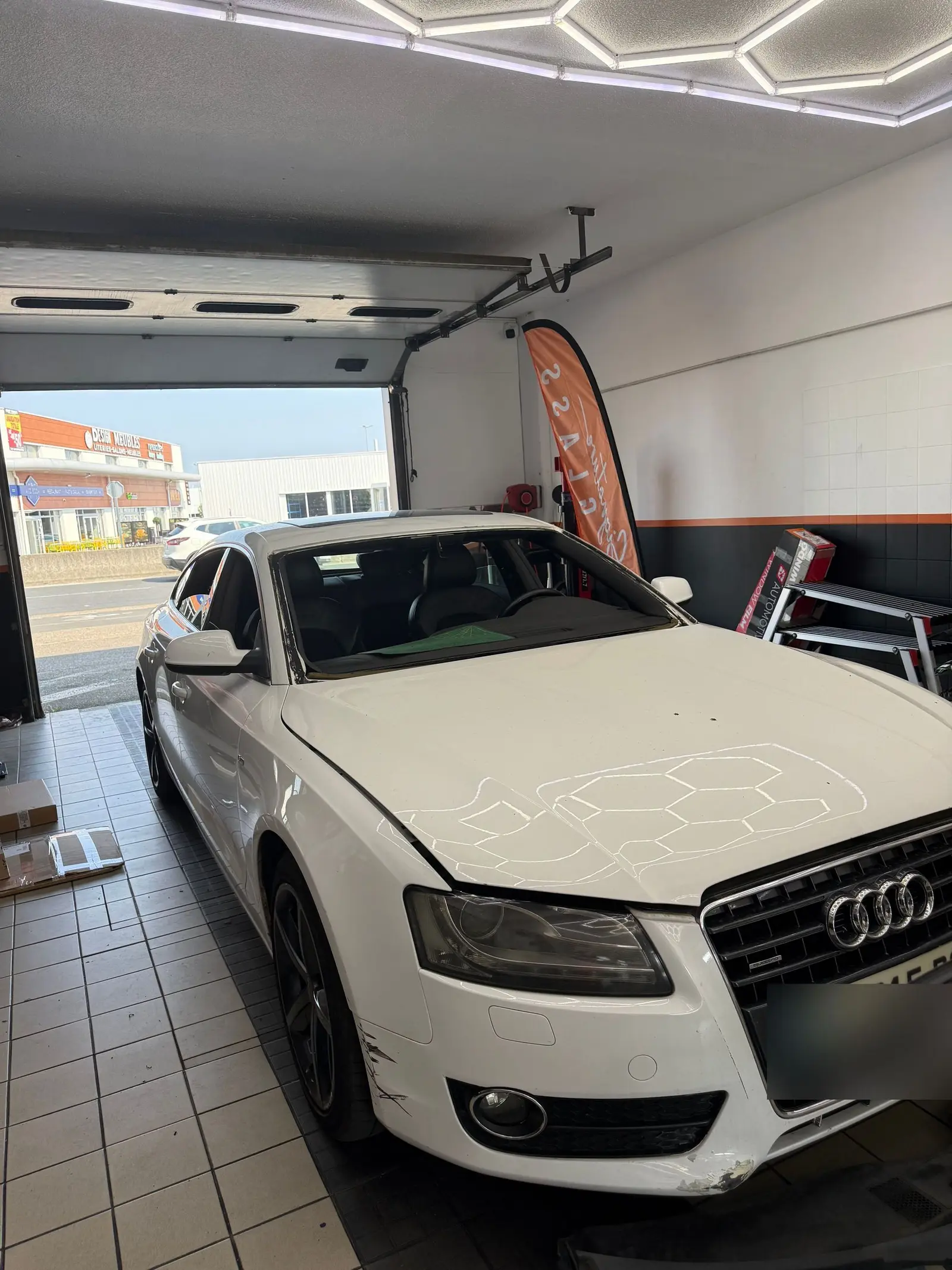 Audi A5 blanche en atelier pour un remplacement de pare-brise