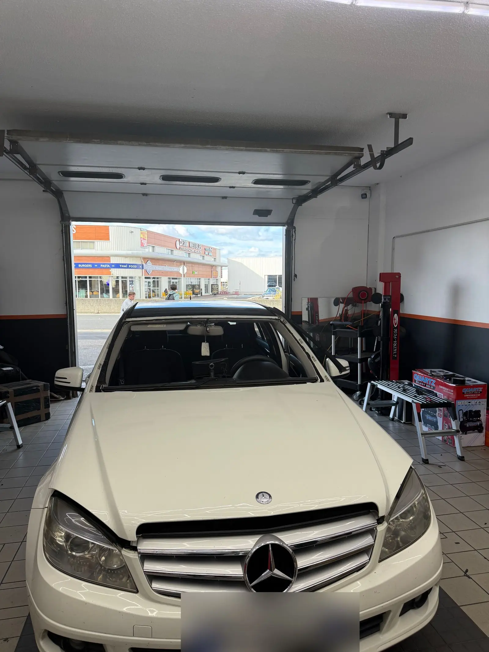 Mercedes Classe C blanche en atelier pour un remplacement de pare-brise