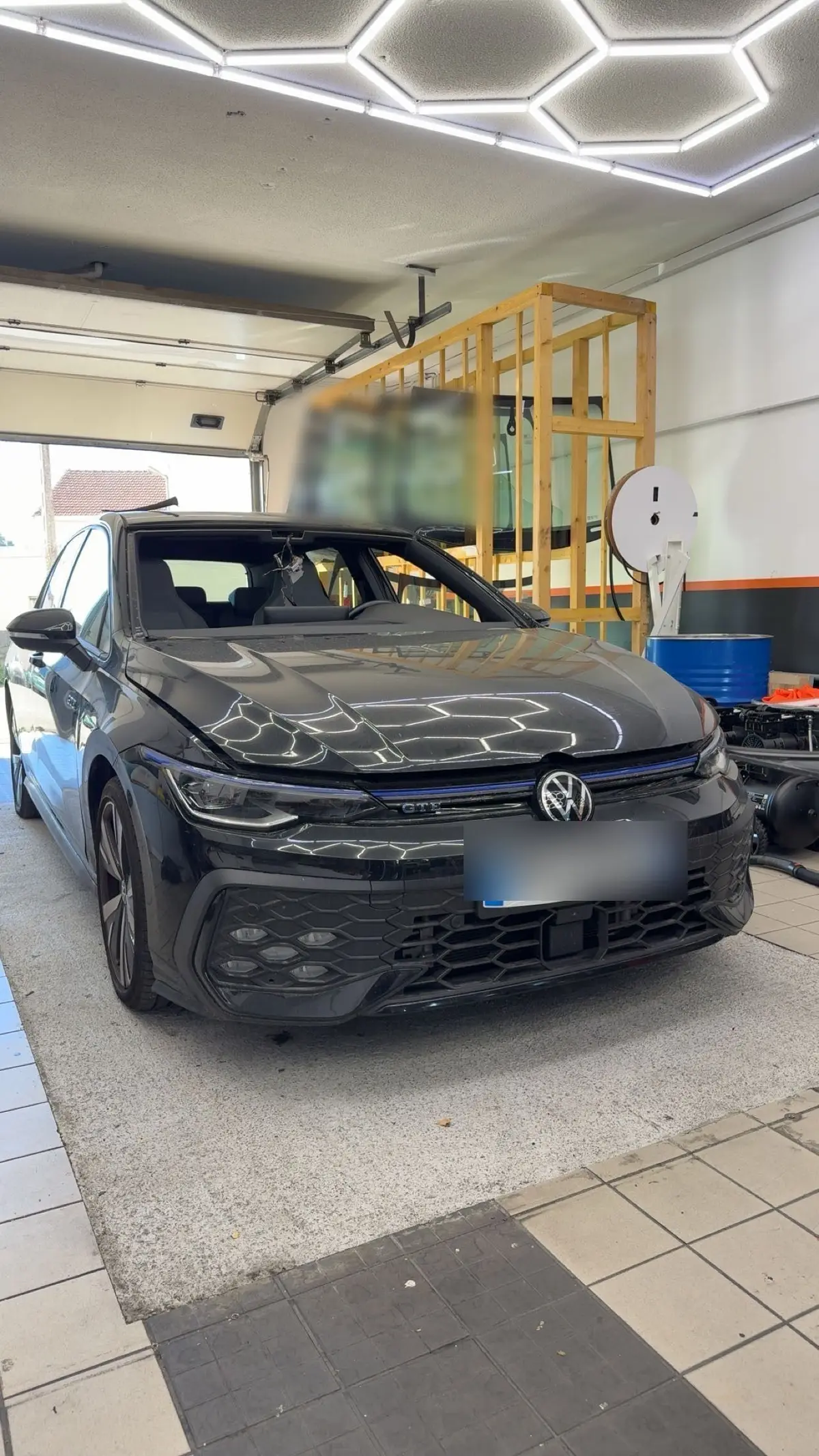 Volkswagen Golf noire en atelier pour un remplacement de pare-brise
